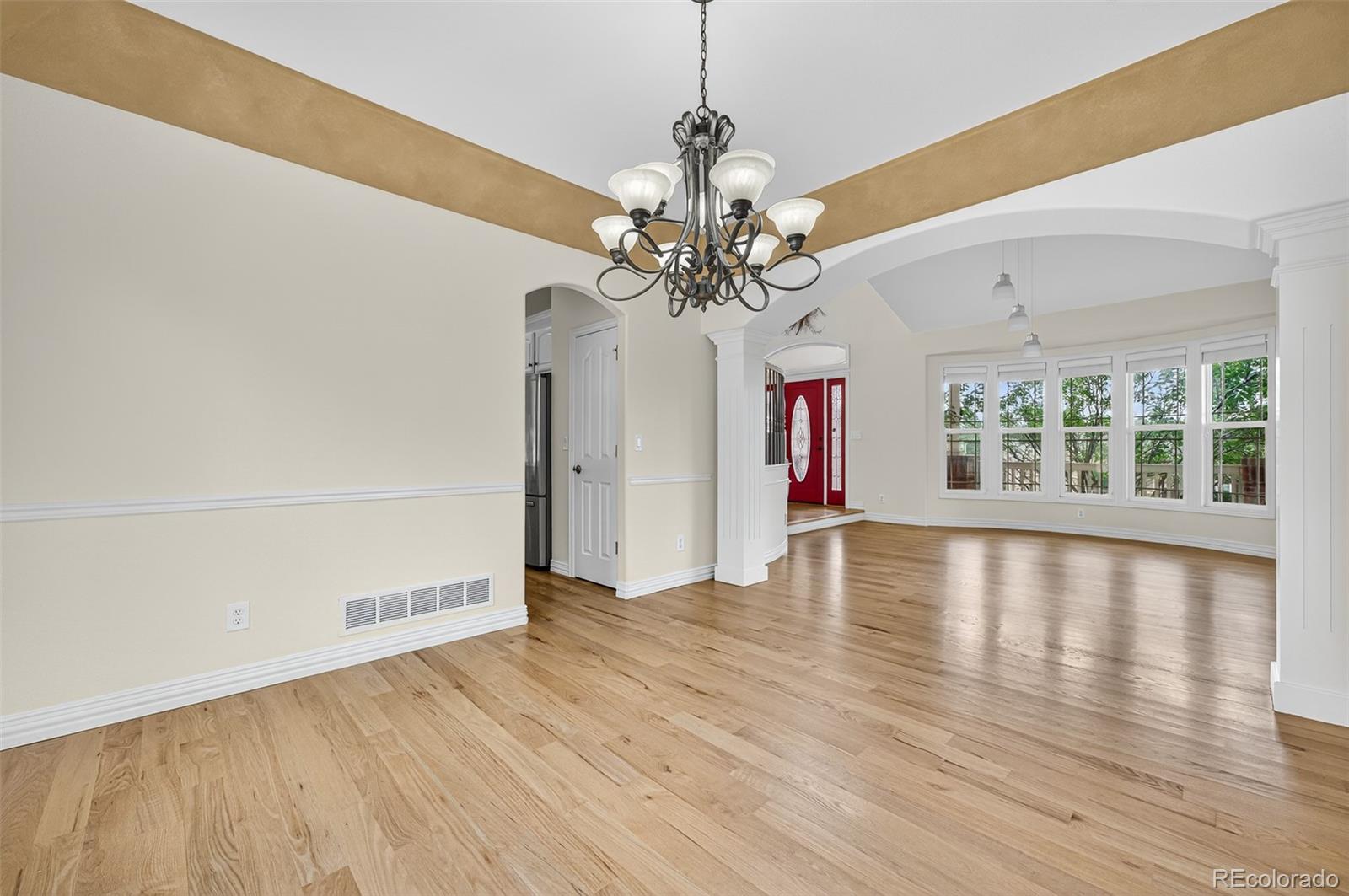 8389 Owl Roost Court Parker, CO 80134 - Photo 21 of 50 a view of a livingroom with wooden floor and a ceiling fan