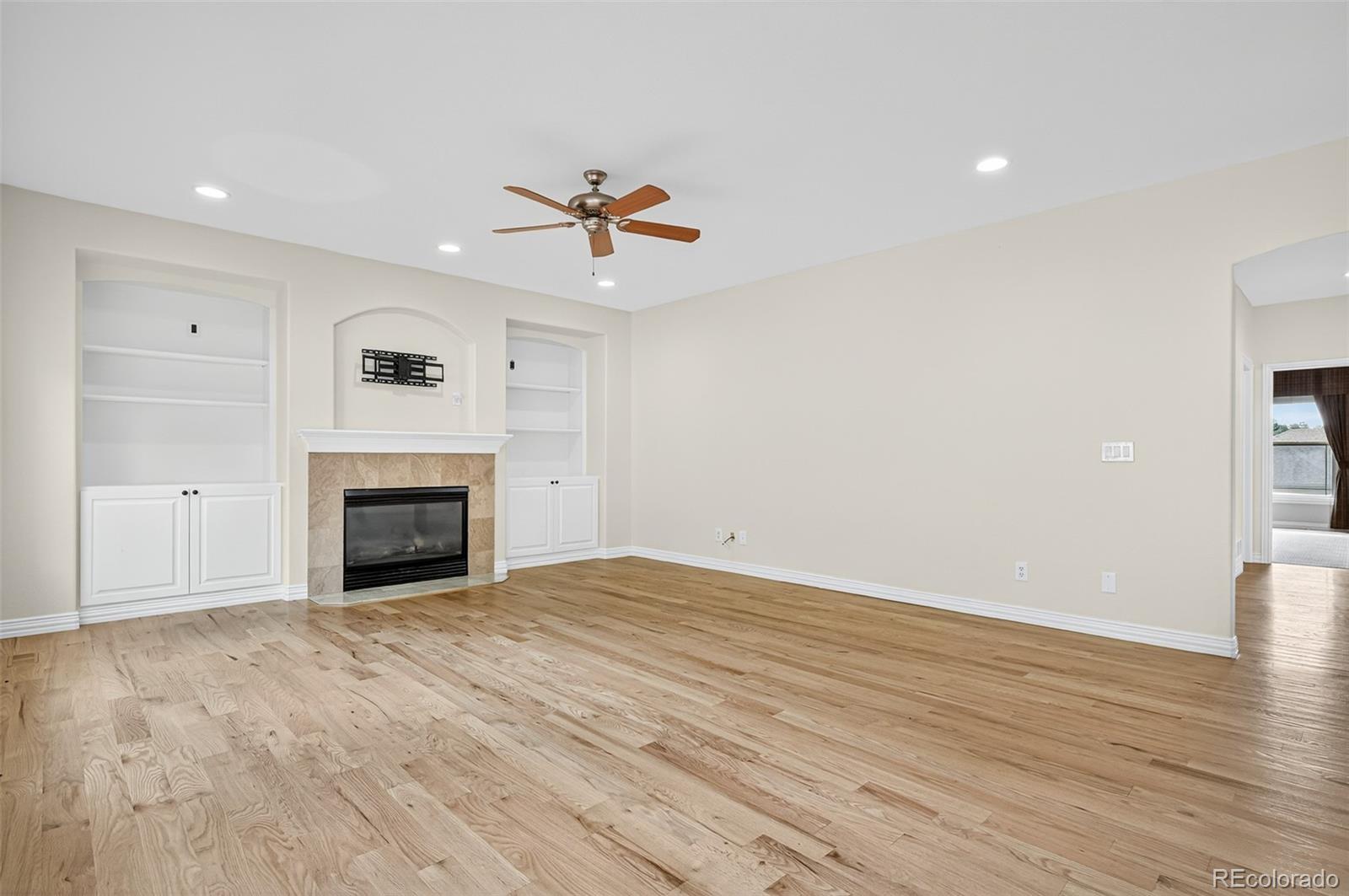 8389 Owl Roost Court Parker, CO 80134 - Photo 23 of 50 a view of empty room with wooden floor and fireplace
