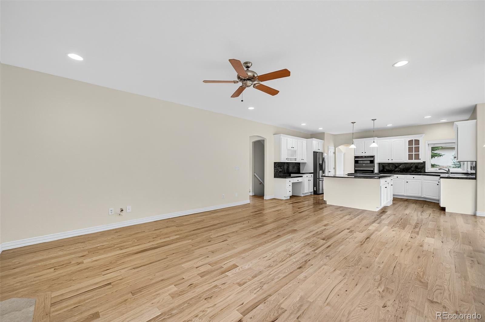 8389 Owl Roost Court Parker, CO 80134 - Photo 24 of 50 a view of an empty room with kitchen appliances and a ceiling fan