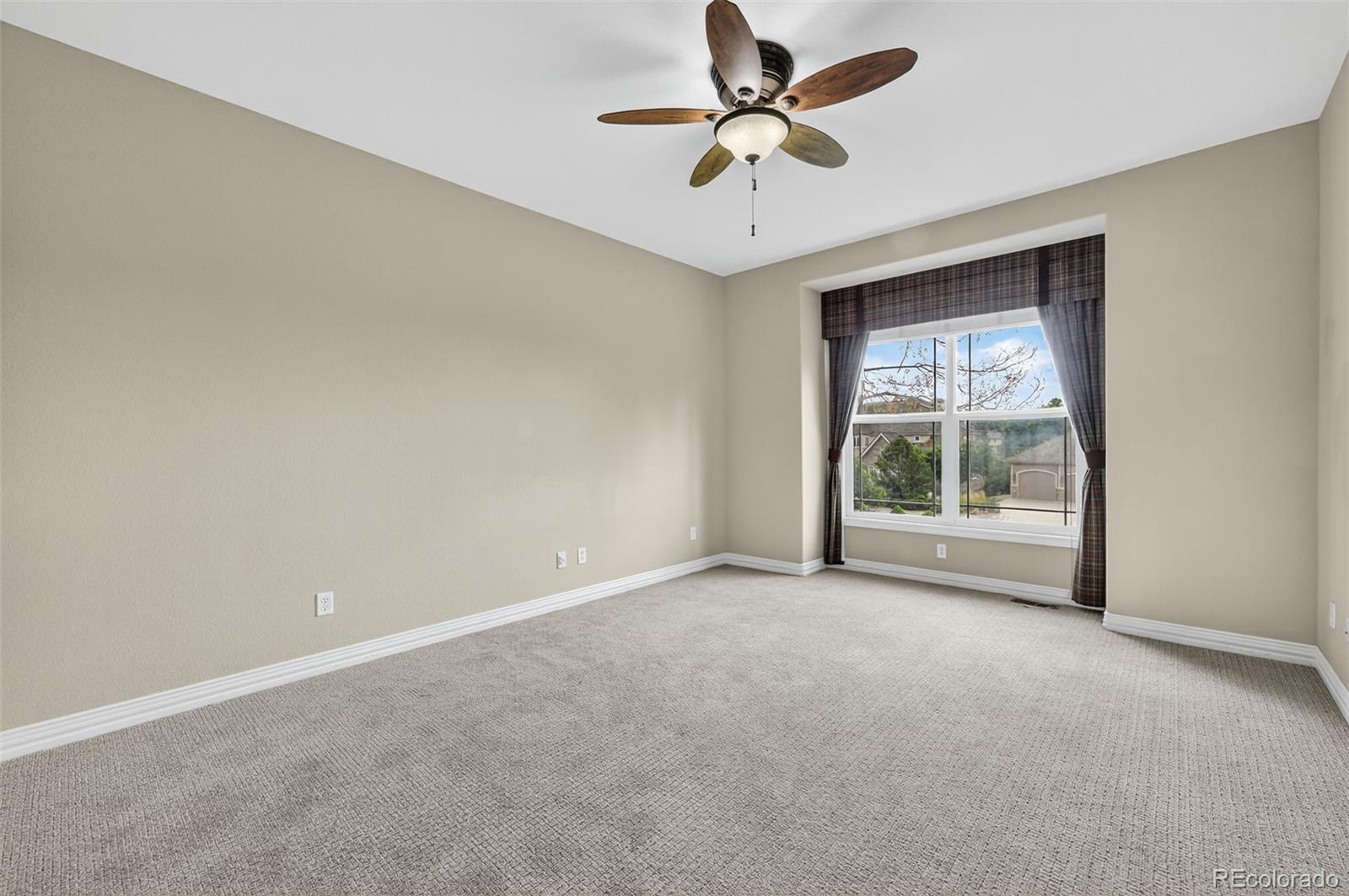 8389 Owl Roost Court Parker, CO 80134 - Photo 32 of 50 an empty room with a window and a fan