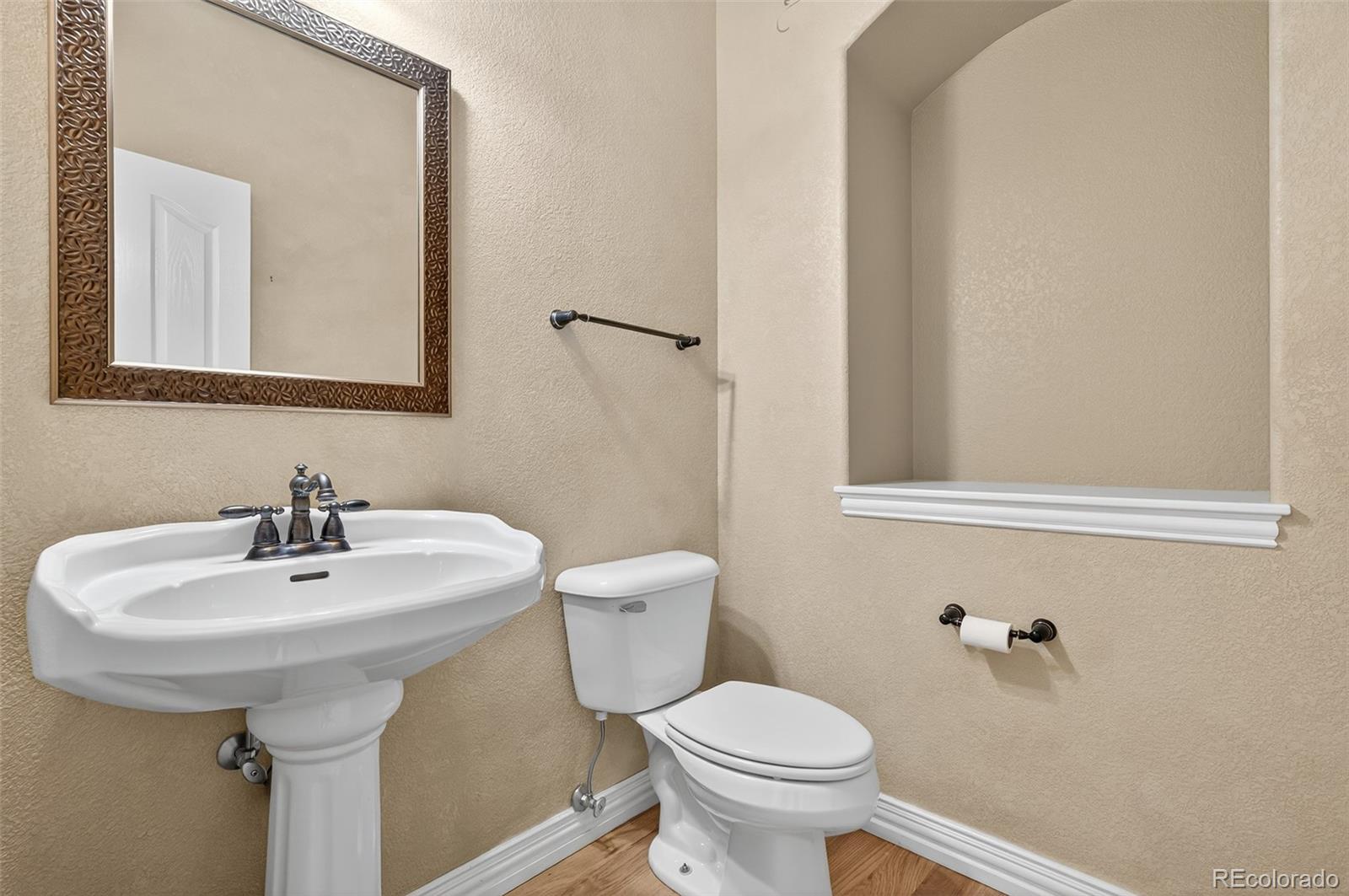 8389 Owl Roost Court Parker, CO 80134 - Photo 34 of 50 a bathroom with a sink toilet and mirror