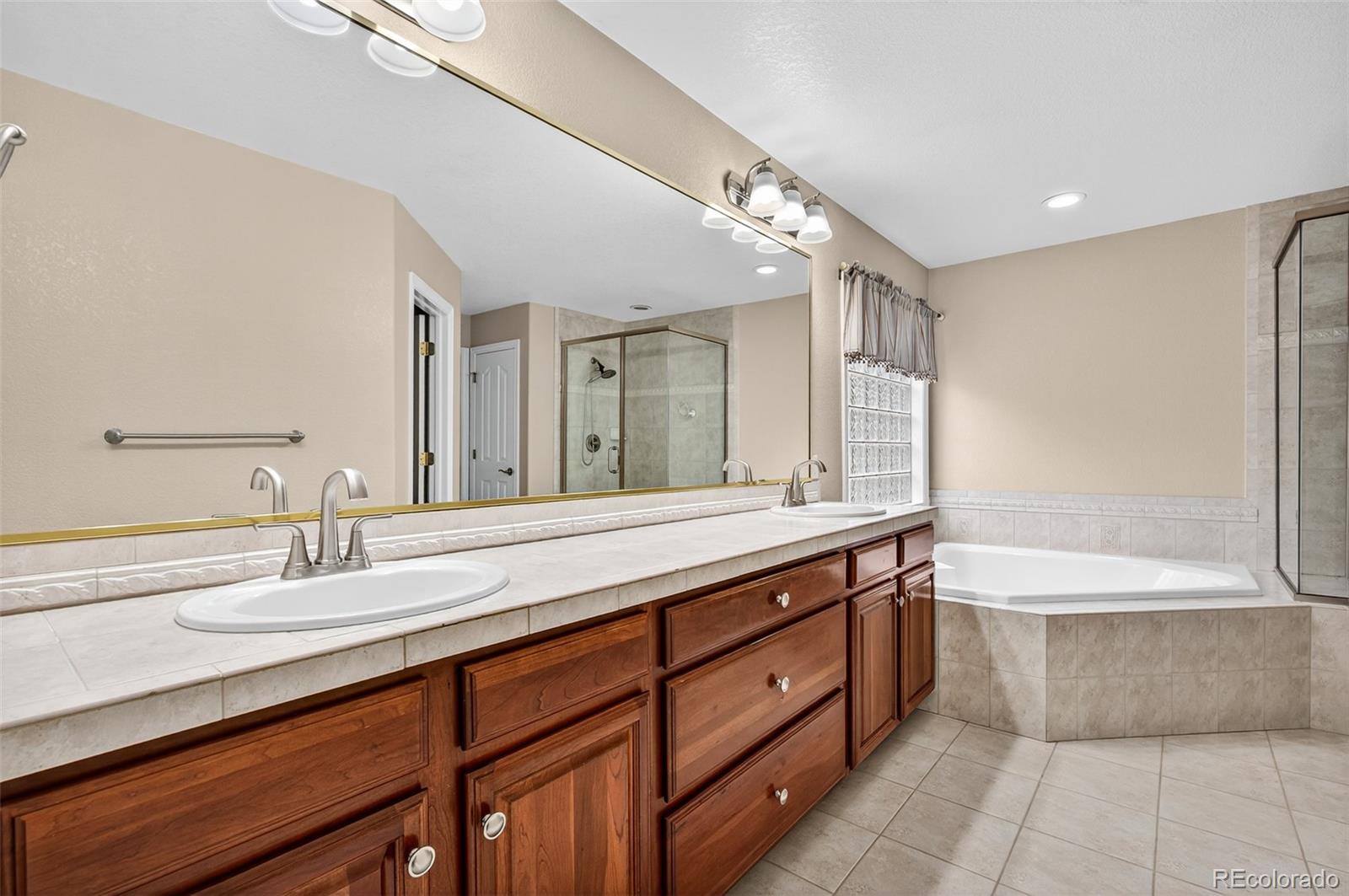 8389 Owl Roost Court Parker, CO 80134 - Photo 40 of 50 a bathroom with a tub sink and mirror
