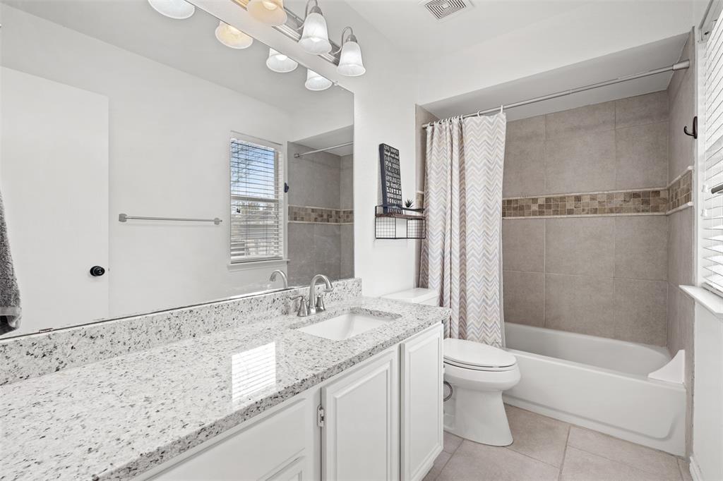 1011 Ridgecrest Drive McKinney, TX 75069 - Photo 23 of 31 Bathroom featuring a white vanity with a speckled countertop, a single undermount sink, and a chrome faucet