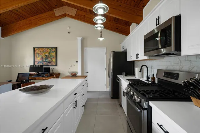 a kitchen with stainless steel appliances a stove a sink a microwave and cabinets