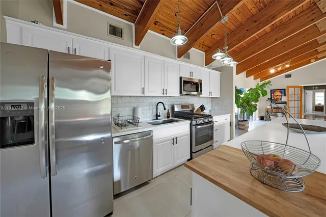 a kitchen with stainless steel appliances granite countertop a sink a stove and a refrigerator
