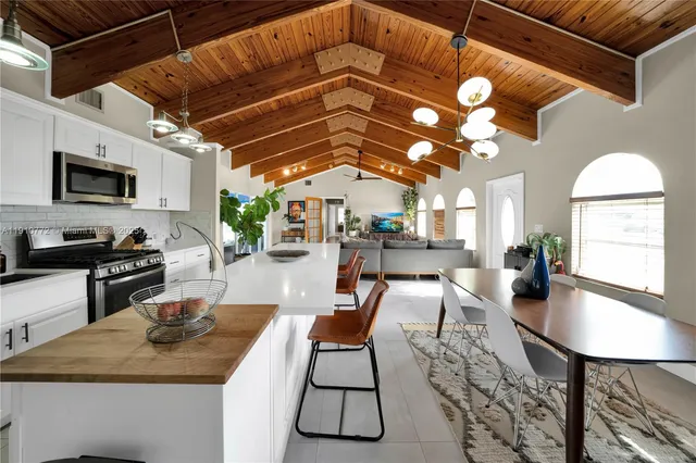 a living room with furniture a flat screen tv and kitchen view