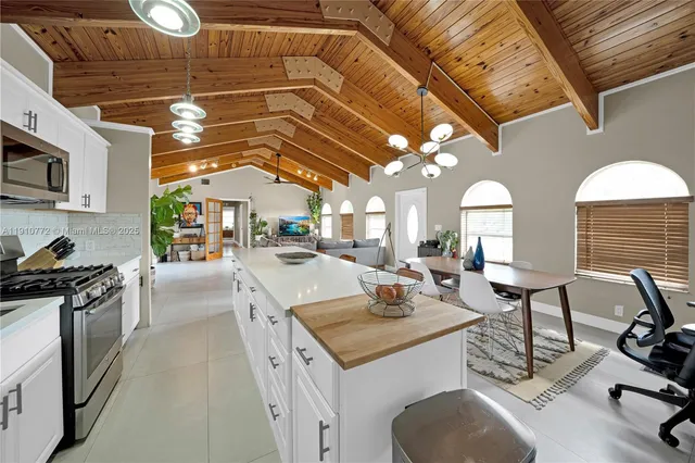 a kitchen with a sink a stove and chairs