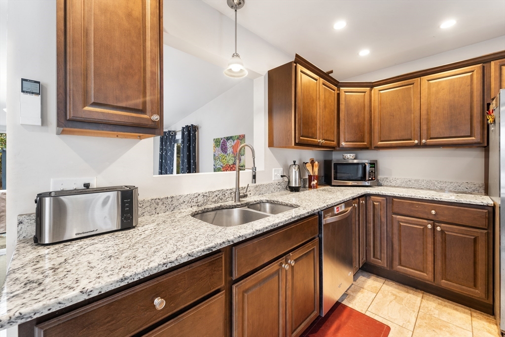 42 South Hunt Road Amesbury, MA 01913 - Photo 5 of 26 a kitchen with granite countertop stainless steel appliances a sink stove and cabinets