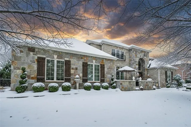 a front view of a house with yard and parking