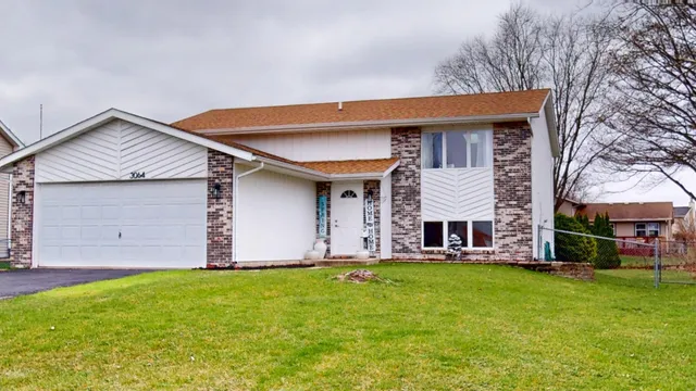 a front view of a house with a yard and trees
