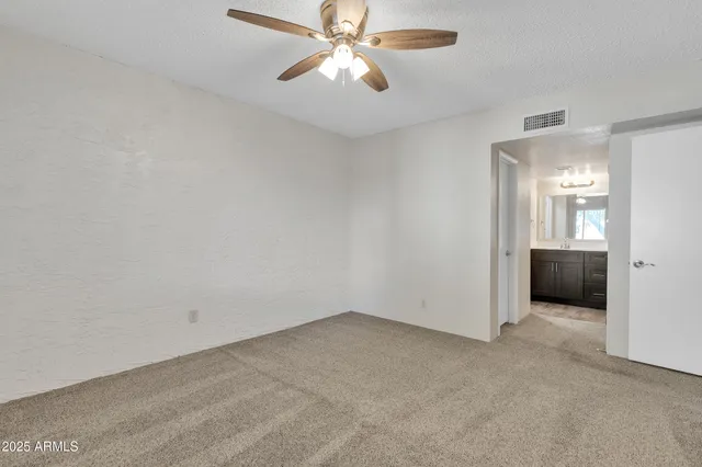 a view of a room with a ceiling fan and a bathroom