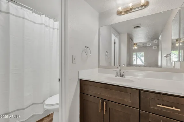 a bathroom with a double vanity sink toilet and a mirror