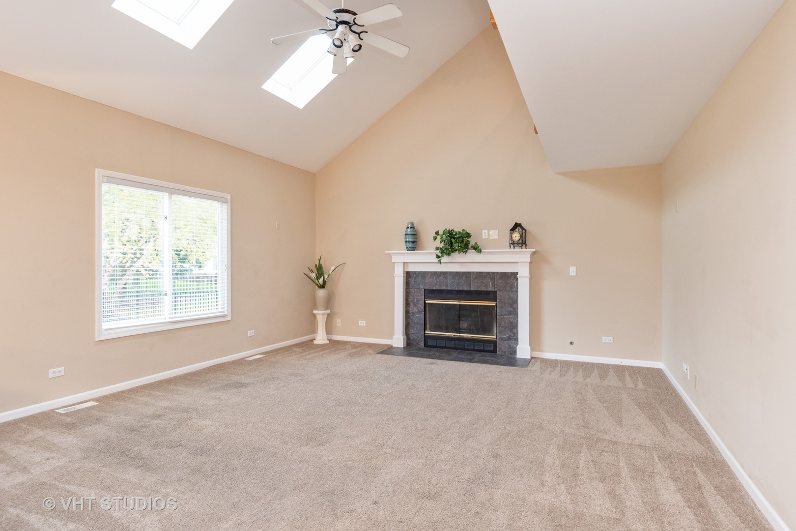 2215 Snow Creek Road Naperville, IL 60564 - Photo 7 of 18 an empty room with windows fireplace and chandelier fan