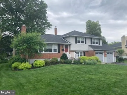 a front view of a house with a yard and potted plants