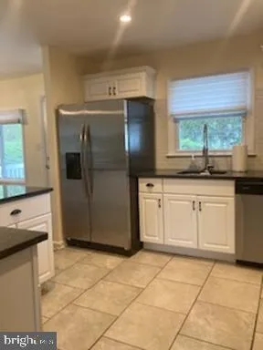 a kitchen with granite countertop a sink cabinets and stainless steel appliances