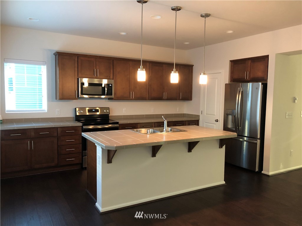 3424 30th Drive Everett, WA 98201 - Photo 4 of 5 a kitchen with a sink a center island a stove a refrigerator and a window