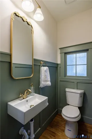 a bathroom with a toilet a sink and mirror