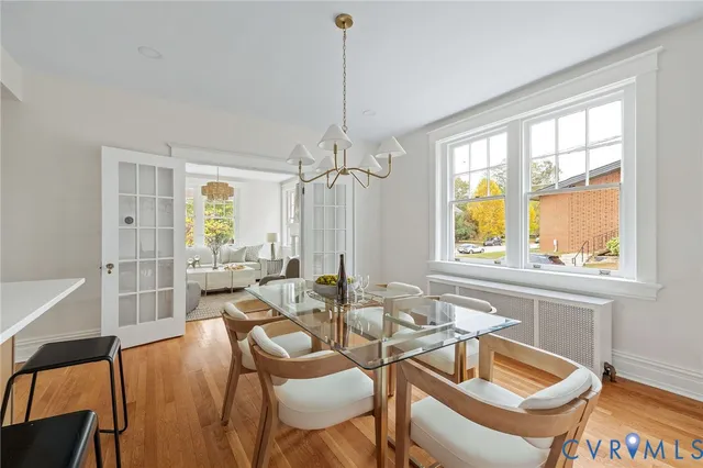 a dining room with furniture a chandelier and wooden floor