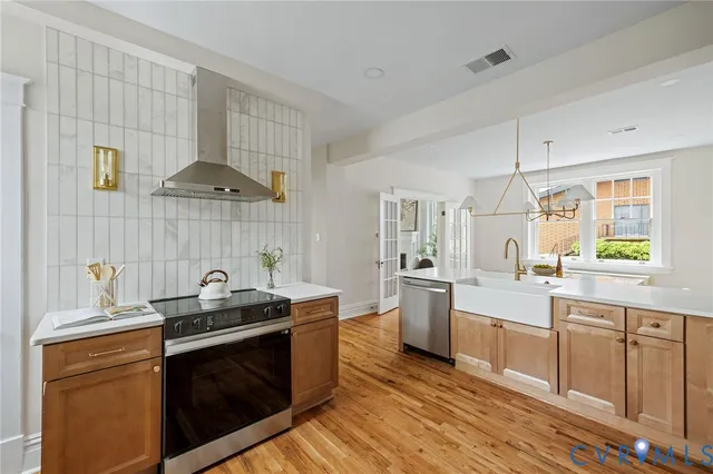 a view of a sink and dishwasher with wooden floor
