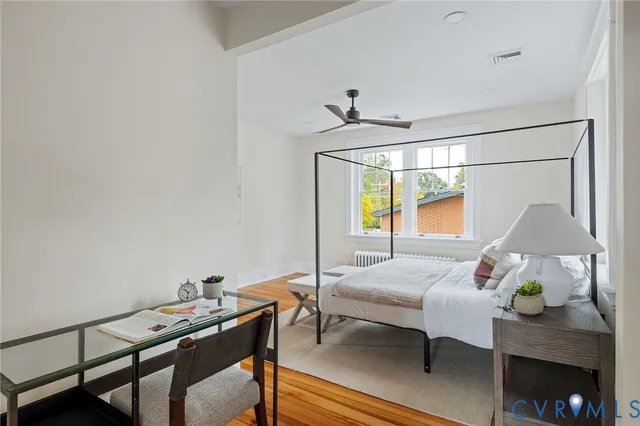 a view of empty room with wooden floor and fan