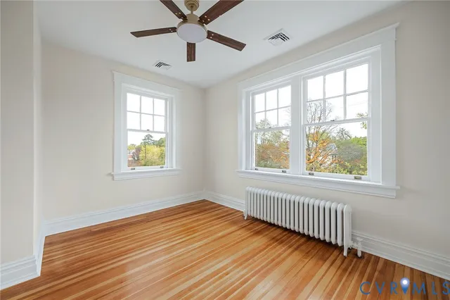 a view of empty room with wooden floor