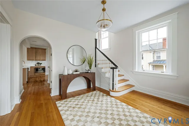 a bedroom with a bed a mirror and a window with wooden floor