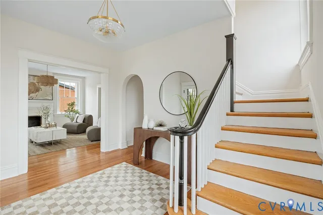 a view of a livingroom with furniture a fireplace a chandelier and wooden floor