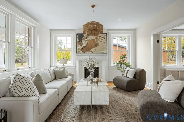 a living room with furniture a fireplace and a large window