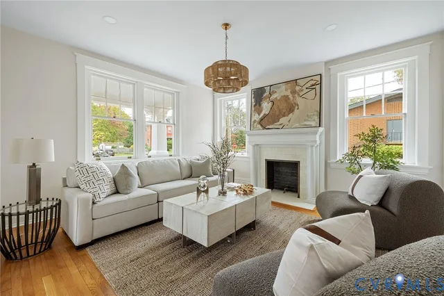 a living room with furniture a fireplace and a large window