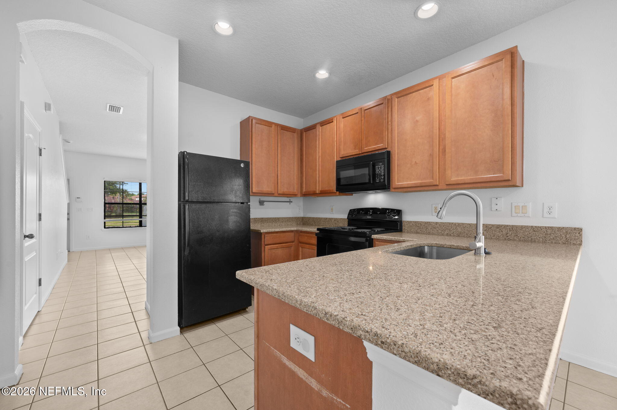 253 Syrah Way St. Augustine, FL 32084 - Photo 16 of 39 a kitchen with granite countertop a refrigerator and a sink