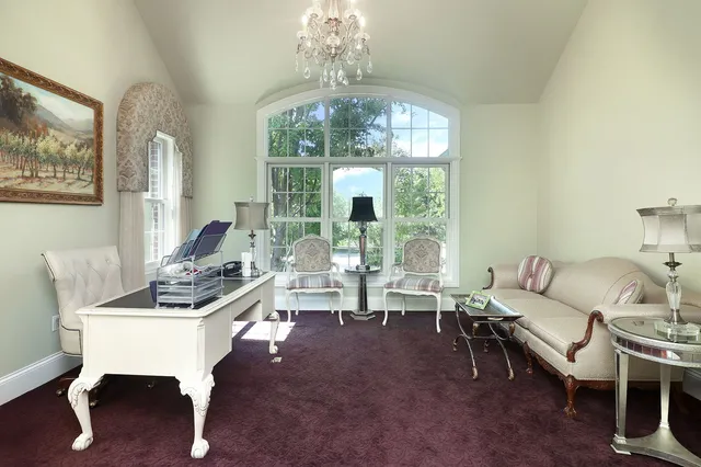 a spacious bedroom with a bed and a chandelier