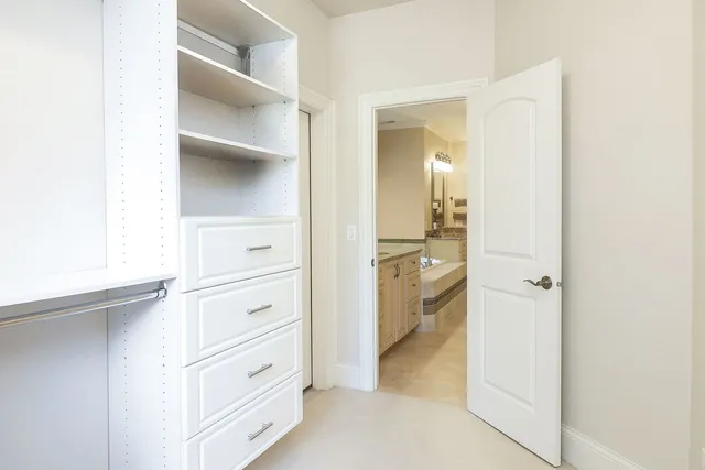 a view of walk in closet with clothes and shoes