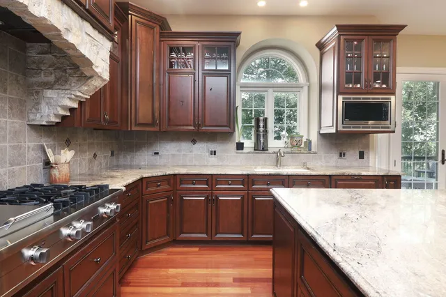 a kitchen with stainless steel appliances granite countertop a stove a sink and a microwave
