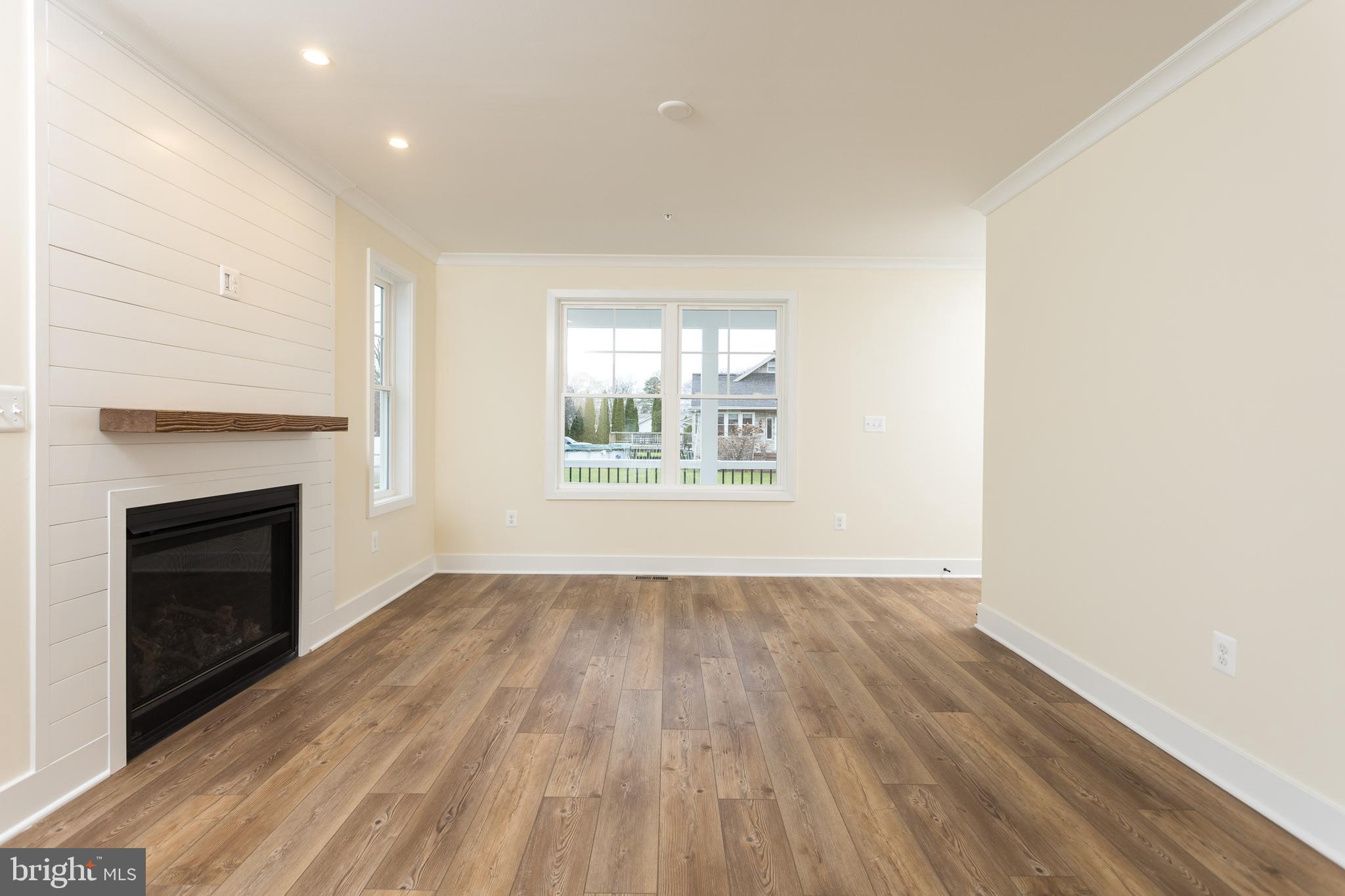 2905 Sparrows Point Road Sparrows Point, MD 21219 - Photo 14 of 32 an empty room with wooden floor fireplace and windows
