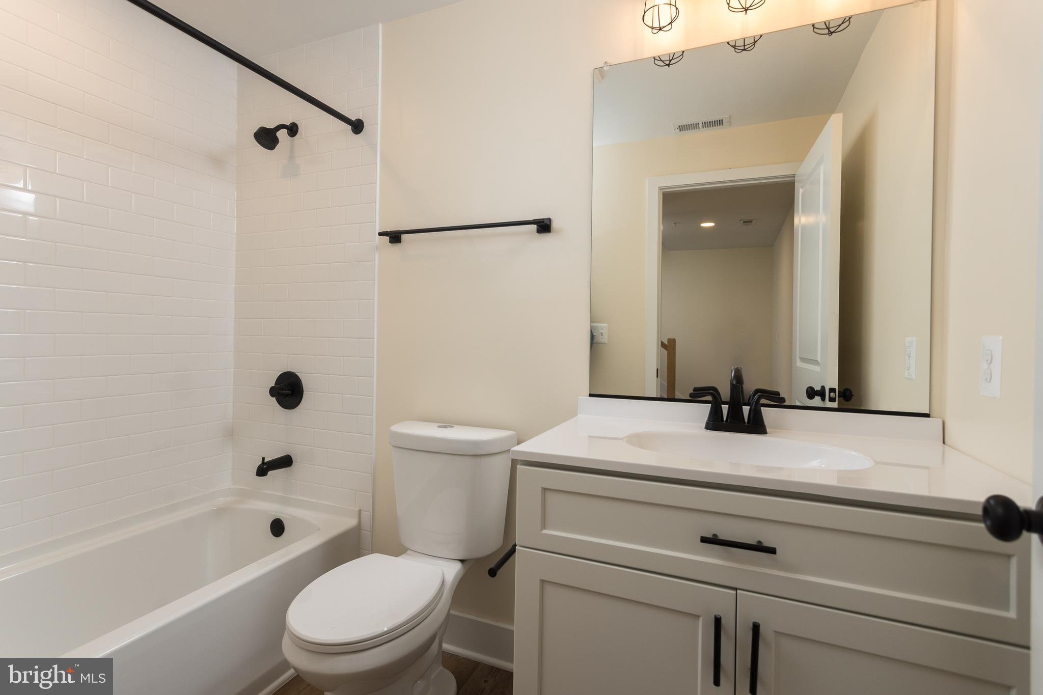 2905 Sparrows Point Road Sparrows Point, MD 21219 - Photo 32 of 32 a bathroom with a granite countertop toilet a sink and a bathtub