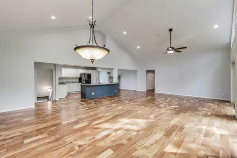 a kitchen with stainless steel appliances granite countertop a stove top oven a sink dishwasher a refrigerator and a oven with wooden floor