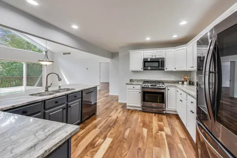 a kitchen with stainless steel appliances granite countertop a stove a sink and a refrigerator