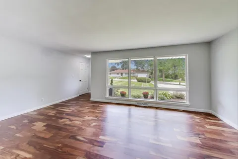 a view of empty room with wooden floor and fireplace