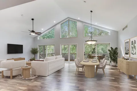 an empty room with wooden floor chandelier and outdoor space
