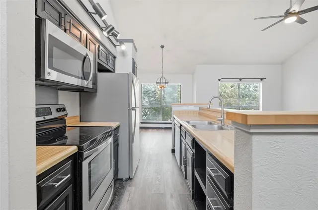 a kitchen with stainless steel appliances granite countertop lots of counter top space and wooden floor