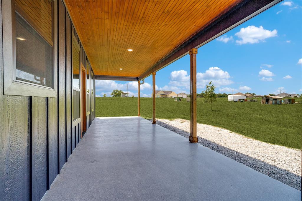 1150 Doss Road Millsap, TX 76066 - Photo 32 of 32 Expansive covered patio with a smooth concrete surface, wood-paneled ceiling, recessed lighting, and exposed timber posts
