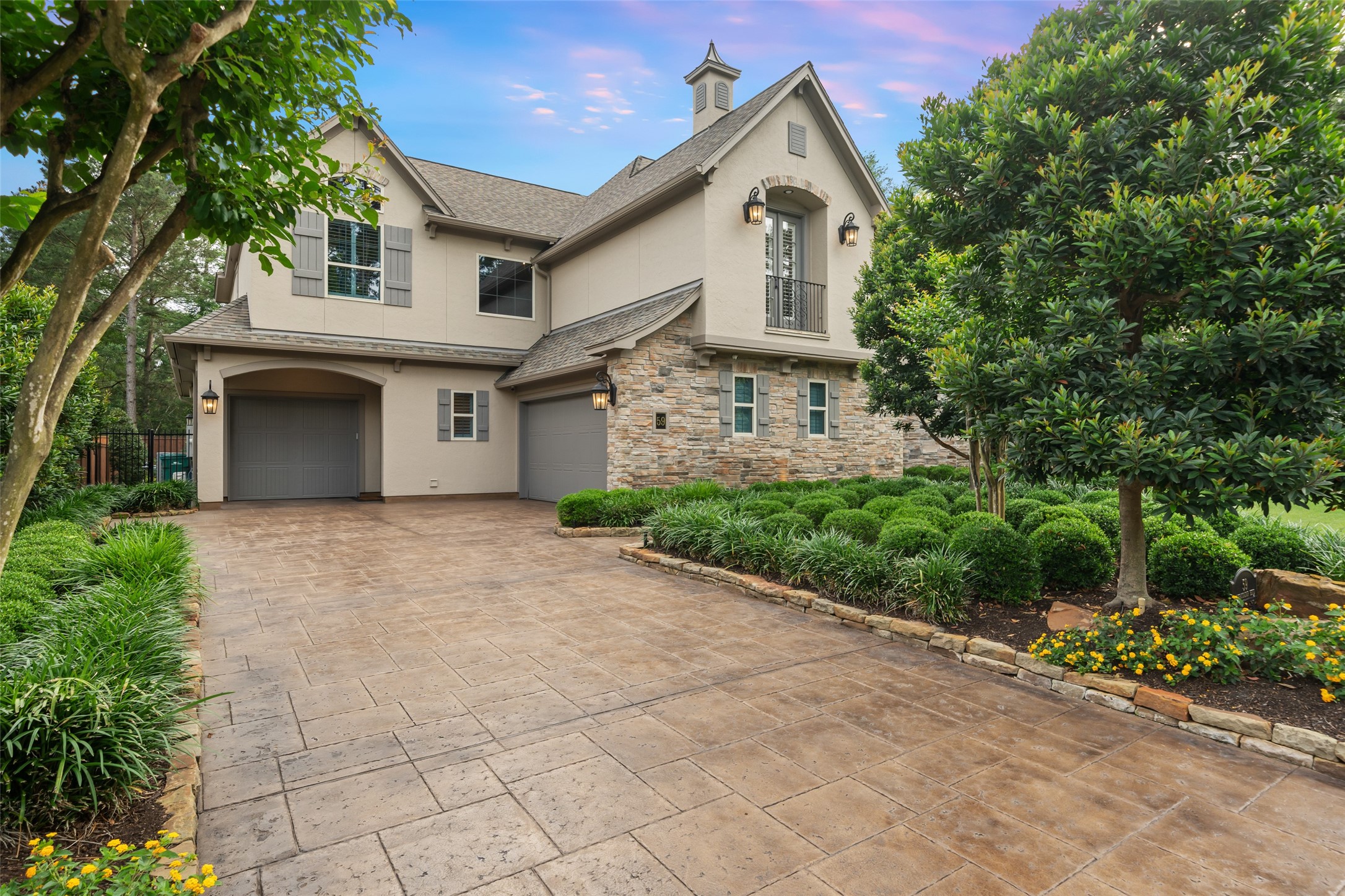 59 East Ambassador Bend Spring, TX 77382 - Photo 2 of 48 The recently glazed and polished motor court leads to two separate and oversized garages and is framed by thoughtfully placed landscaping and mature trees. It creates a beautiful approach to the home. This well-designed exterior detail enhances the property’s curb appeal with both charm and sophistication.