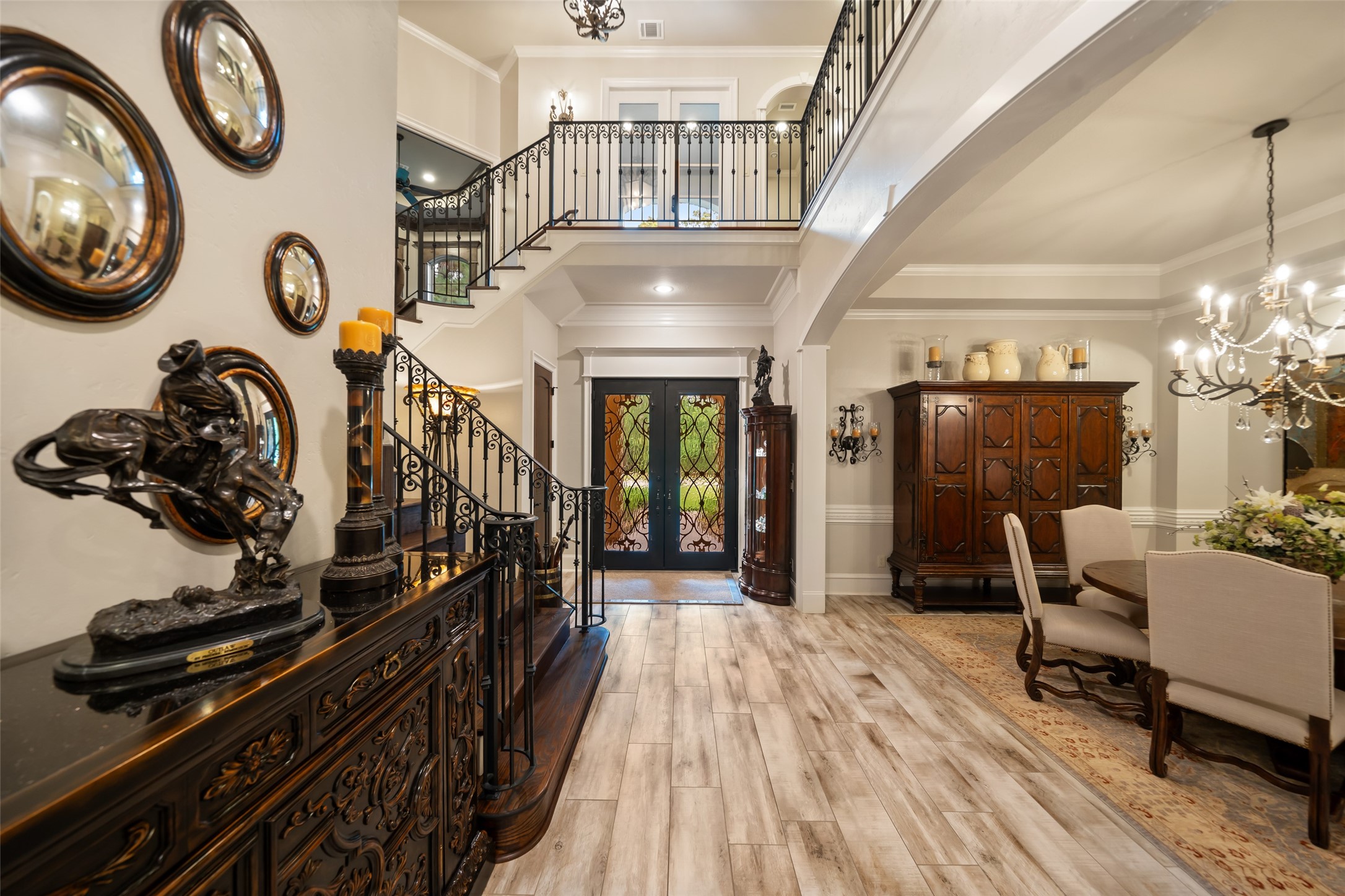 59 East Ambassador Bend Spring, TX 77382 - Photo 3 of 48 The formal entryway makes a bold, unforgettable first impression. Cantera wrought iron and glass custom front doors and the stunning wood staircase serve as a striking focal point, elevating the space while adding depth and architectural interest.