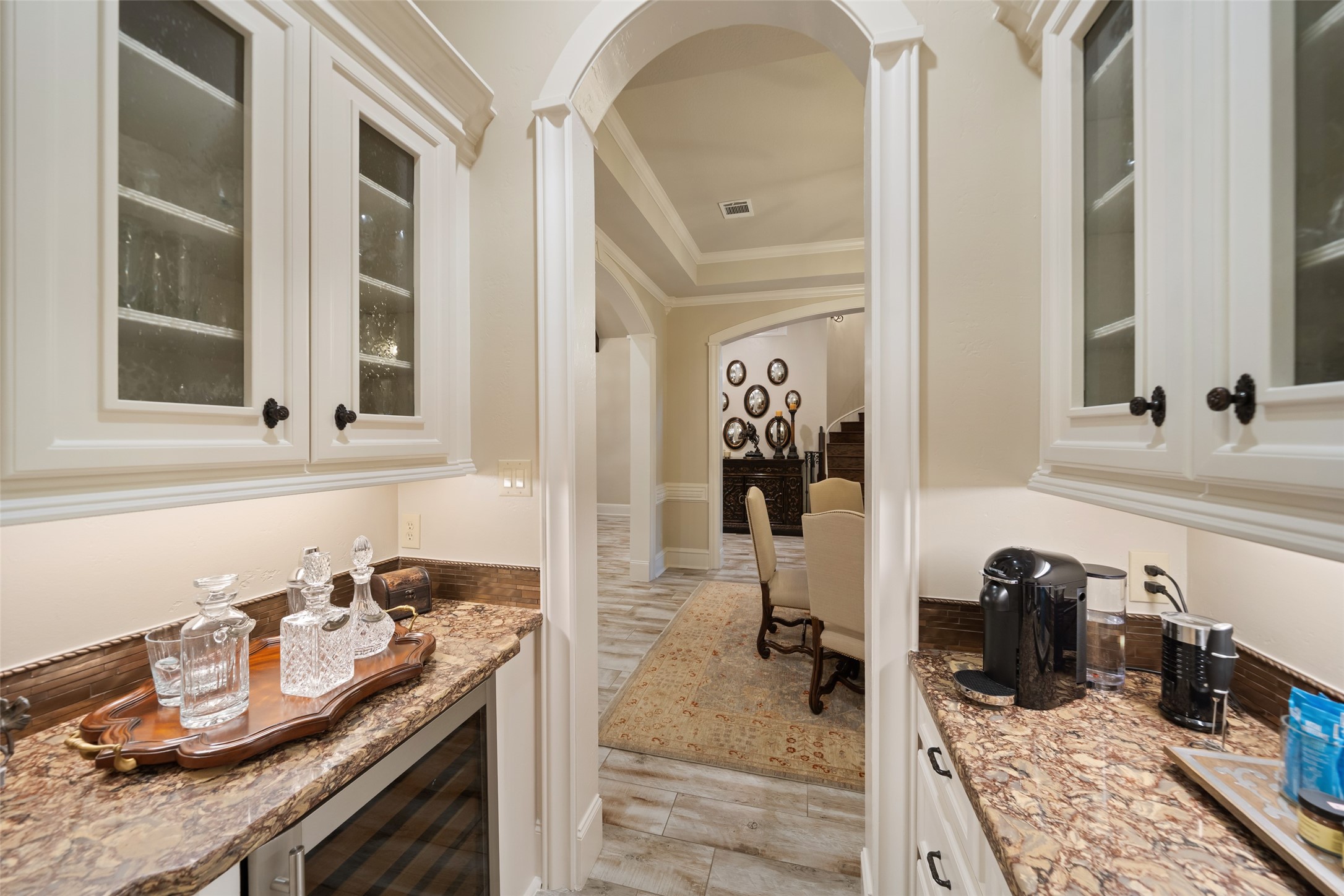 59 East Ambassador Bend Spring, TX 77382 - Photo 6 of 48 This conveniently placed butler’s pantry connects the dining room to the culinary space, featuring custom cabinetry with glass-front upper cabinetry for display and storage. The space also features a beverage fridge.