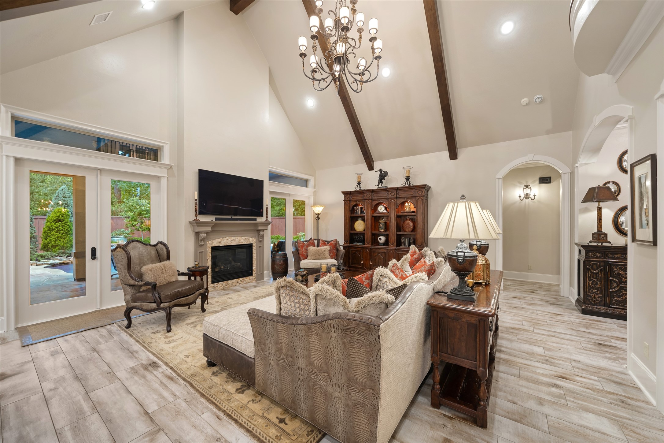 59 East Ambassador Bend Spring, TX 77382 - Photo 9 of 48 The expansive living room flows effortlessly into the outdoor living space, creating a seamless transition to the patio and pool area, all with a beautiful view of the backyard.
