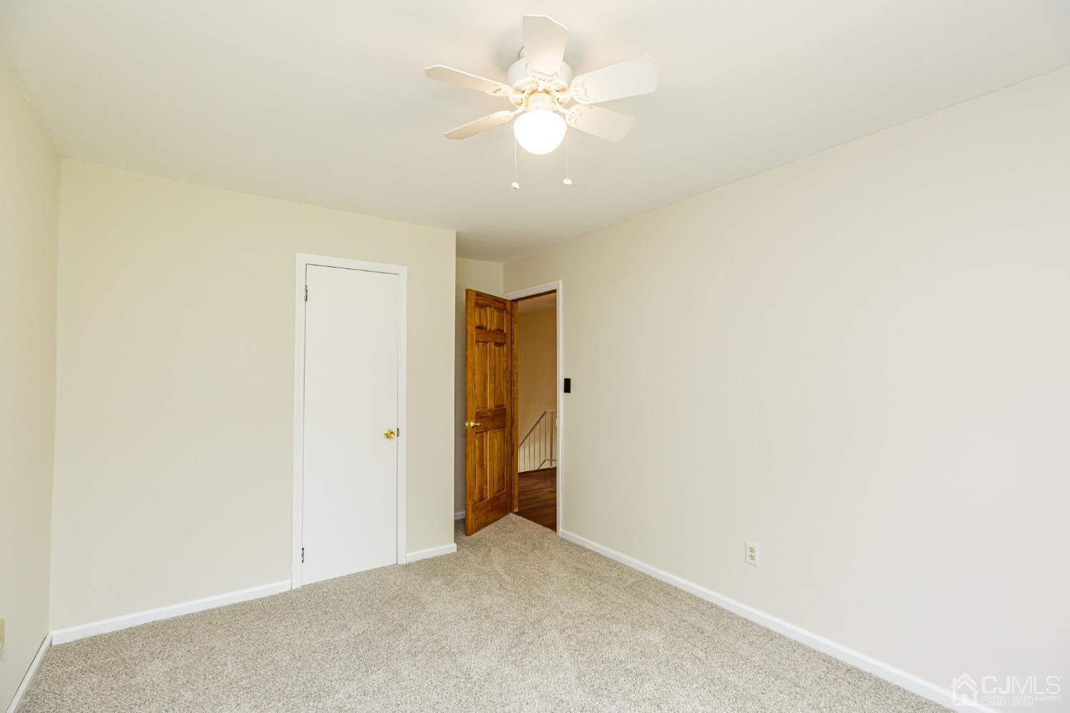 335 Alpine Court, Unit 35 Stanhope, NJ 07874 - Photo 29 of 32 an empty room with a ceiling fan and a window