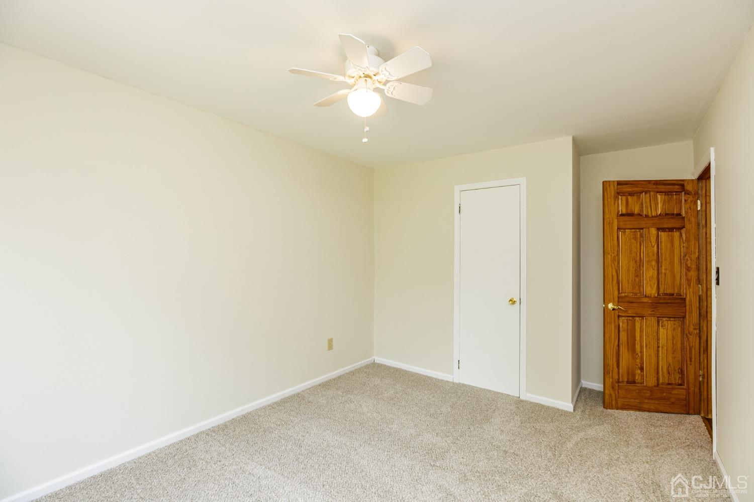 335 Alpine Court, Unit 35 Stanhope, NJ 07874 - Photo 30 of 32 an empty room with a ceiling fan and a window