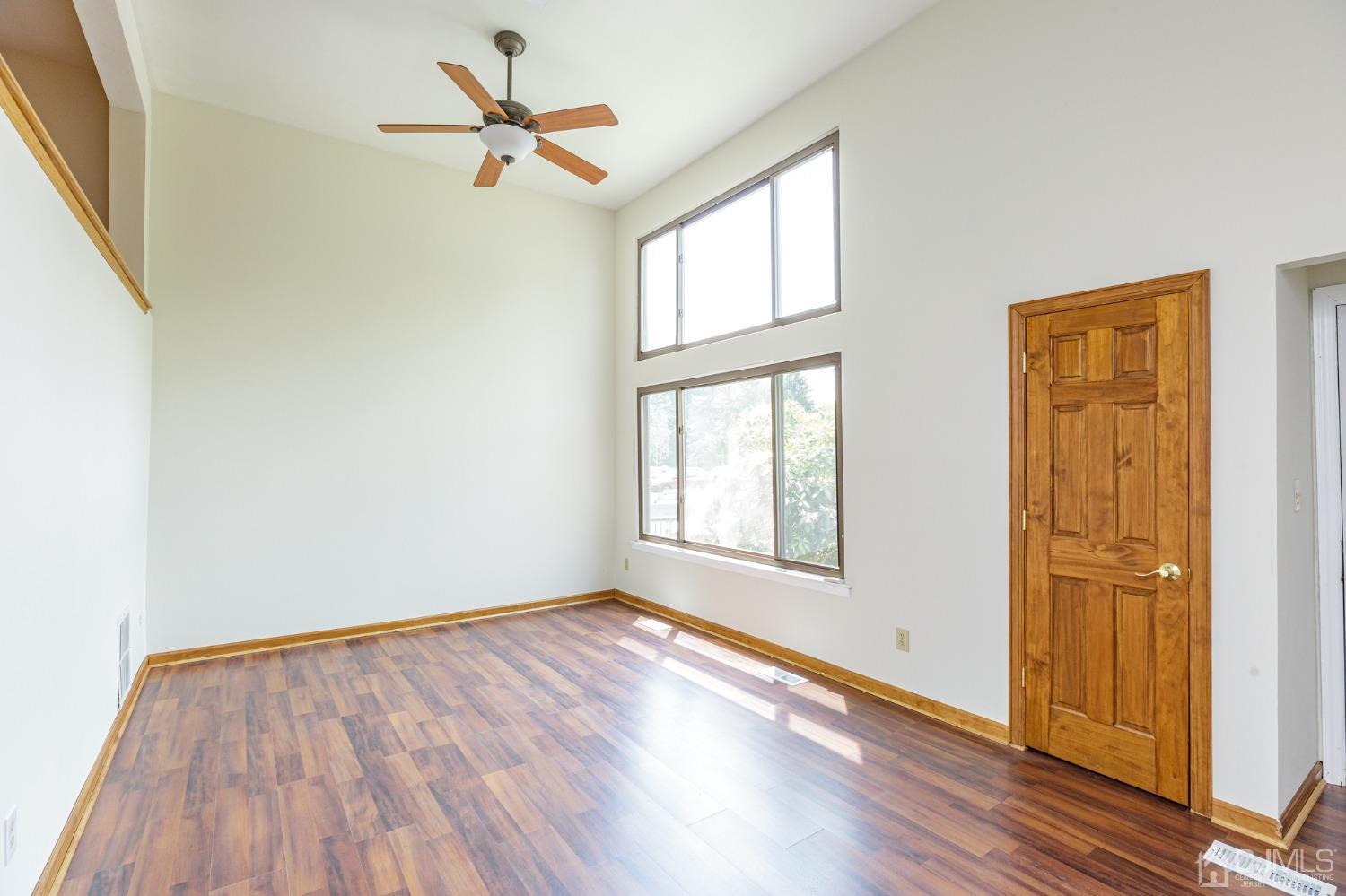 335 Alpine Court, Unit 35 Stanhope, NJ 07874 - Photo 4 of 32 an empty room with wooden floor ceiling fan and windows