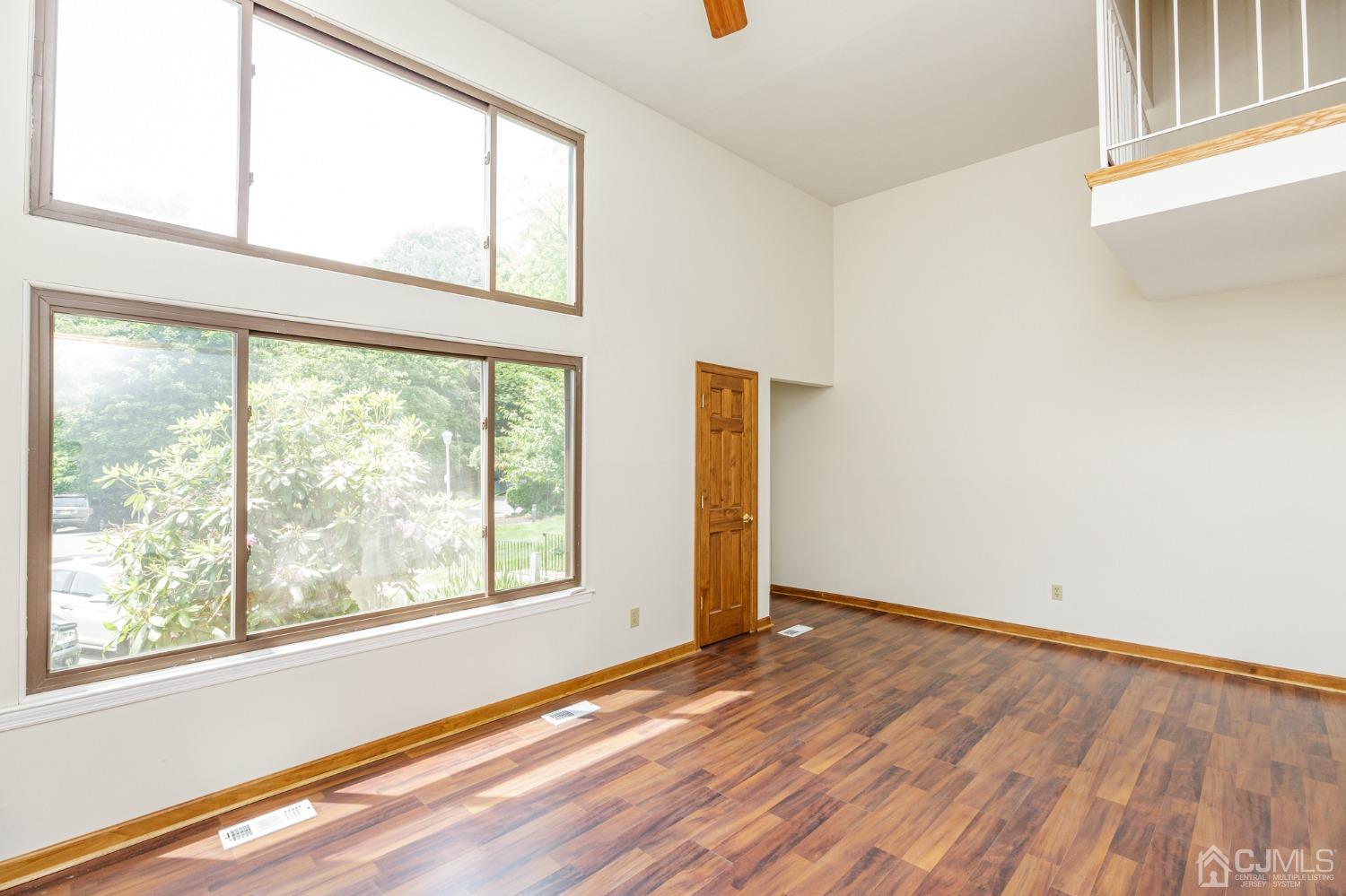 335 Alpine Court, Unit 35 Stanhope, NJ 07874 - Photo 6 of 32 an empty room with wooden floor and windows