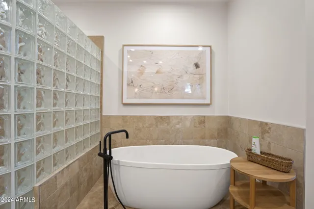 a bedroom with a bed a mirror and a window